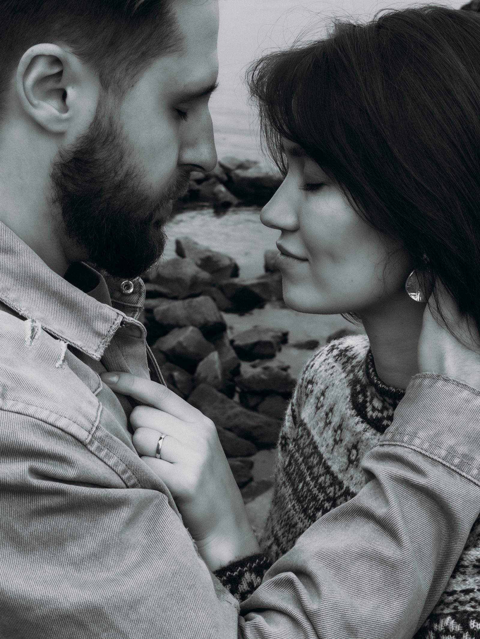 Love couple embrace rocky shore black and white