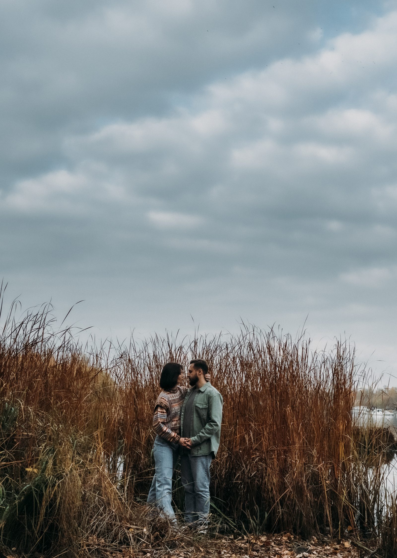 Love couple embrace tall reeds lakeside portrait