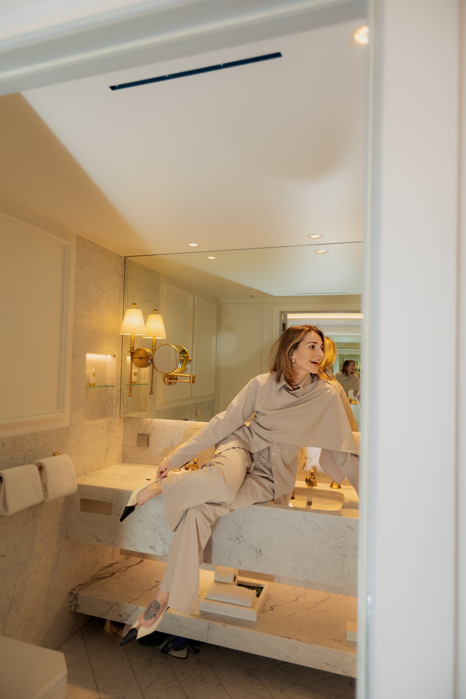 Sara marble bathroom putting on heels hotel editorial