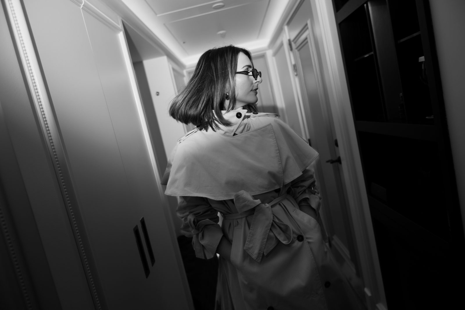 Sara cream trench walking dark hallway black and white