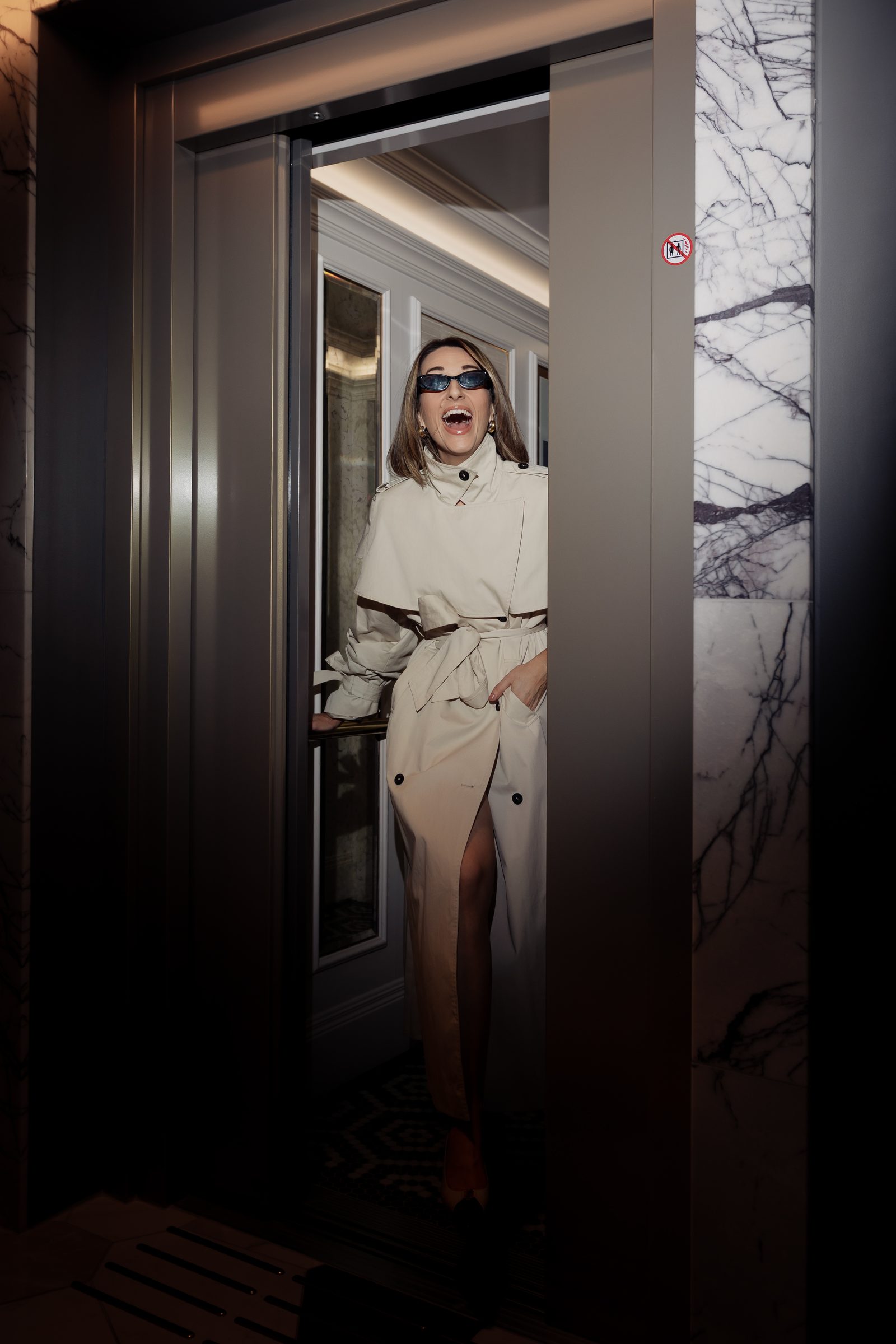 Sara cream trench laughing elevator doorway