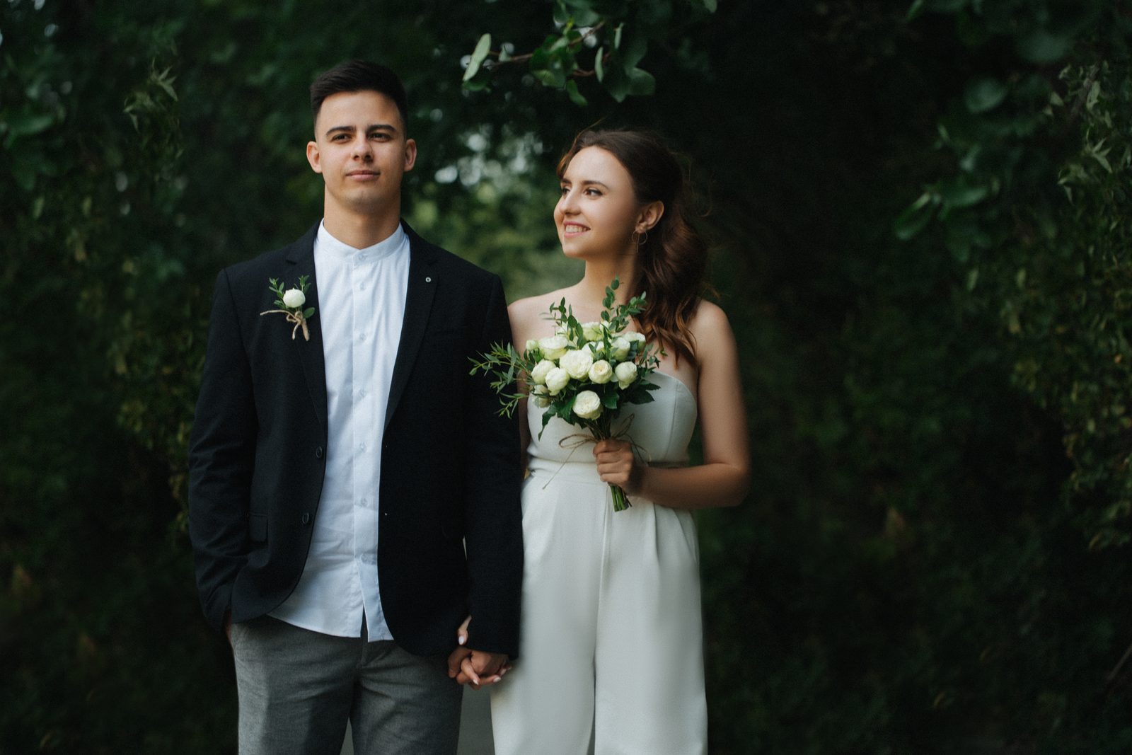 Wedding bride groom standing portrait holding hands garden