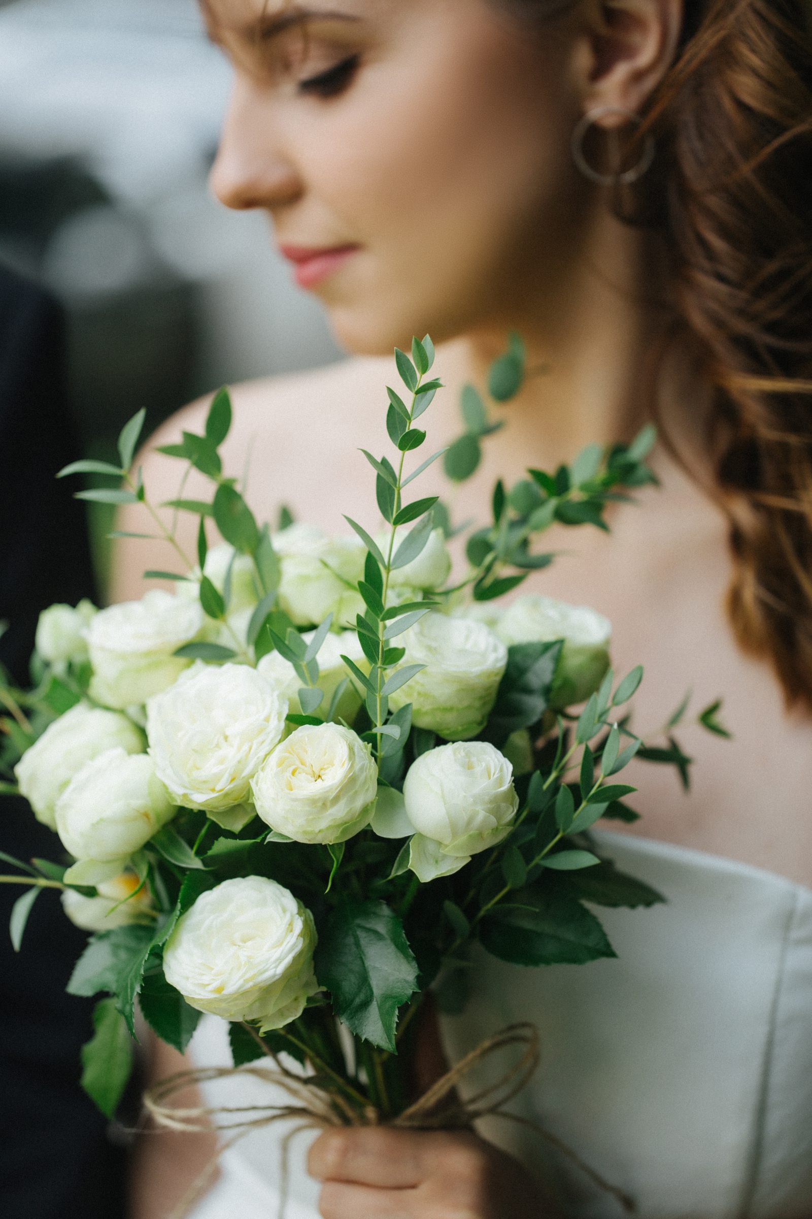 Wedding bride holding white garden rose bouquet close up