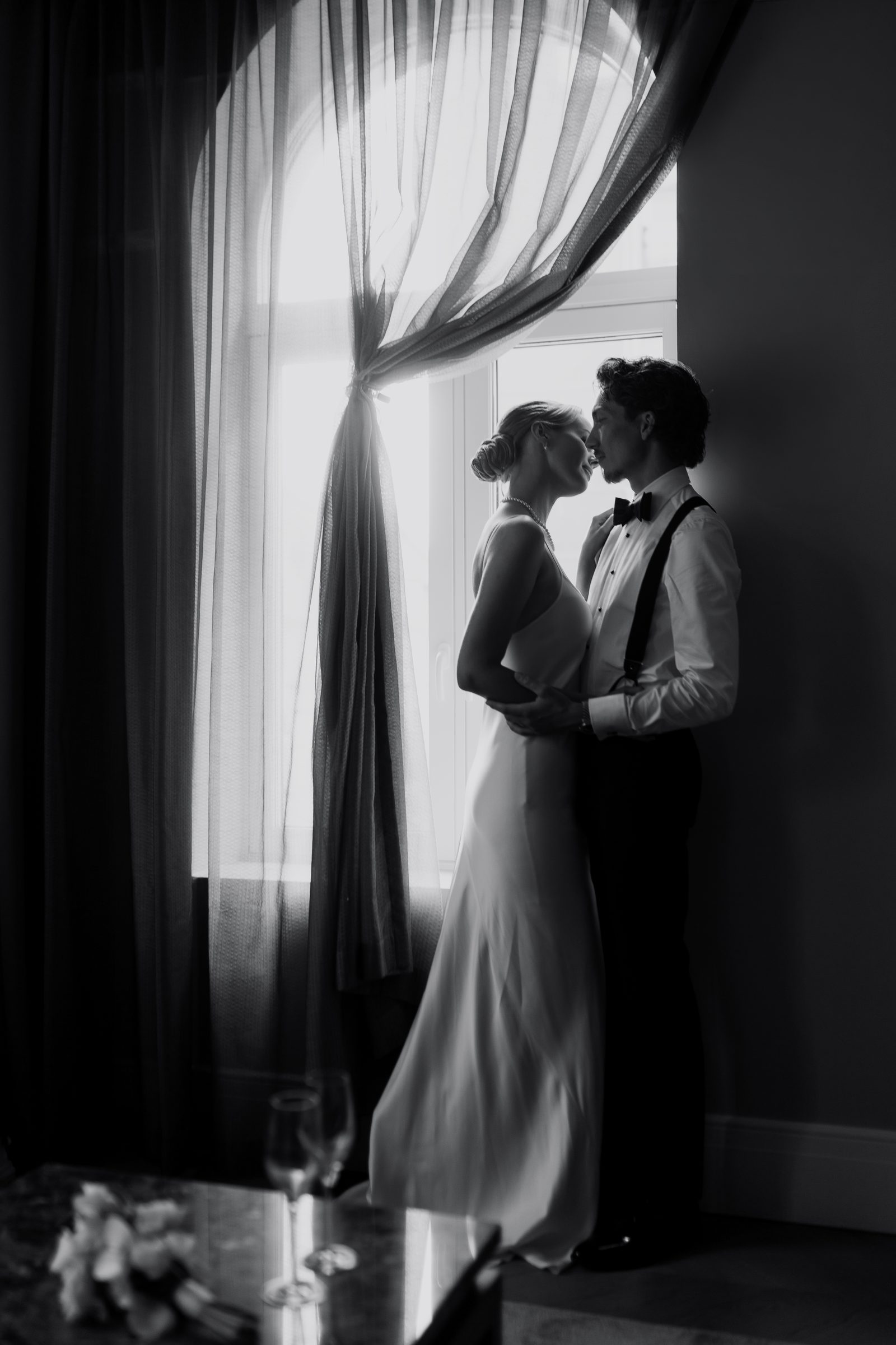 Wedding couple embrace window silhouette bw